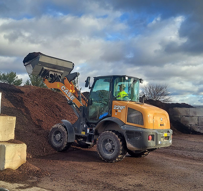 Case Machine scooping mulch from the bins