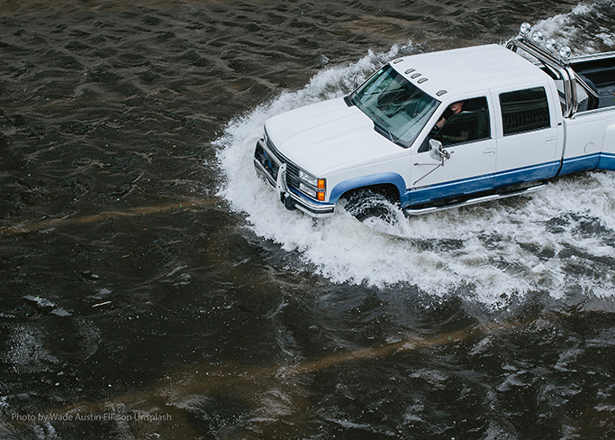 Truck driving through flooded street