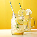 Lemonade in a mason jar on yellow background